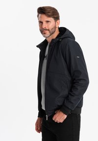 Herren navy huva jacka tillverkad av mjukt tyg. Har dragkedja, ribbade ärmslut och två framfickor. Designad med en minimalistisk stil.