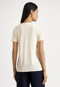 Κοντομάνικο T-shirt από βαμβάκι σε ανοιχτό μπεζ, με στρογγυλή λαιμόκοψη και χαλαρή εφαρμογή, με λεία υφή και ελάχιστες ραφές.