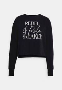 Felpa nera a maniche lunghe, realizzata in tessuto morbido, con una grande scritta bianca: "REBEL & Rule BREAKER." Maniche lunghe con polsini.