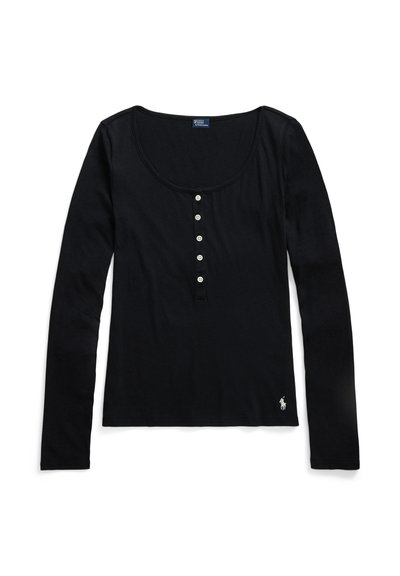 Chemise Henley noire à manches longues avec un col en U, cinq boutons blancs sur le devant et un petit logo brodé blanc près de l'ourlet.