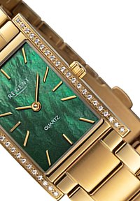 Montre en quartz doré avec un cadran vert texturé, des index horaires dorés et une lunette ornée de cristaux. Boîtier rectangulaire et bracelet à maillons.