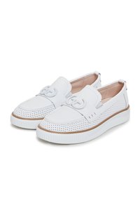 Paire de chaussures décontractées blanches à enfiler avec côtés perforés, bouts ronds, semelles en caoutchouc et boucle décorative sur le dessus.