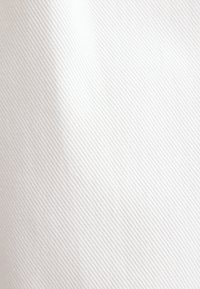 Tissu blanc texturé avec un motif diagonal subtil, présentant une surface lisse et un léger éclat réfléchissant.