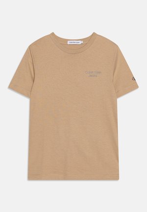 Beżowa koszulka z krótkim rękawem i okrągłym dekoltem z małym logo "Calvin Klein Jeans" na piersi i rękawie, gładki wzór, bawełniana tkanina.