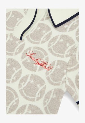 Adīta polo krekls krēmkrāsā ar beigu smaidu sejas motīvu. Iezīmēts ar tumši zilu apkakli un sarkanu "SmileyWorld" izšuvumu uz krūtīm.