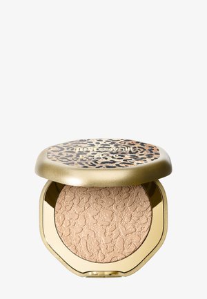 Poudre compacte de maquillage avec surface beige texturée dans un étui doré, surmontée d’un couvercle imprimé léopard avec le texte de la marque.