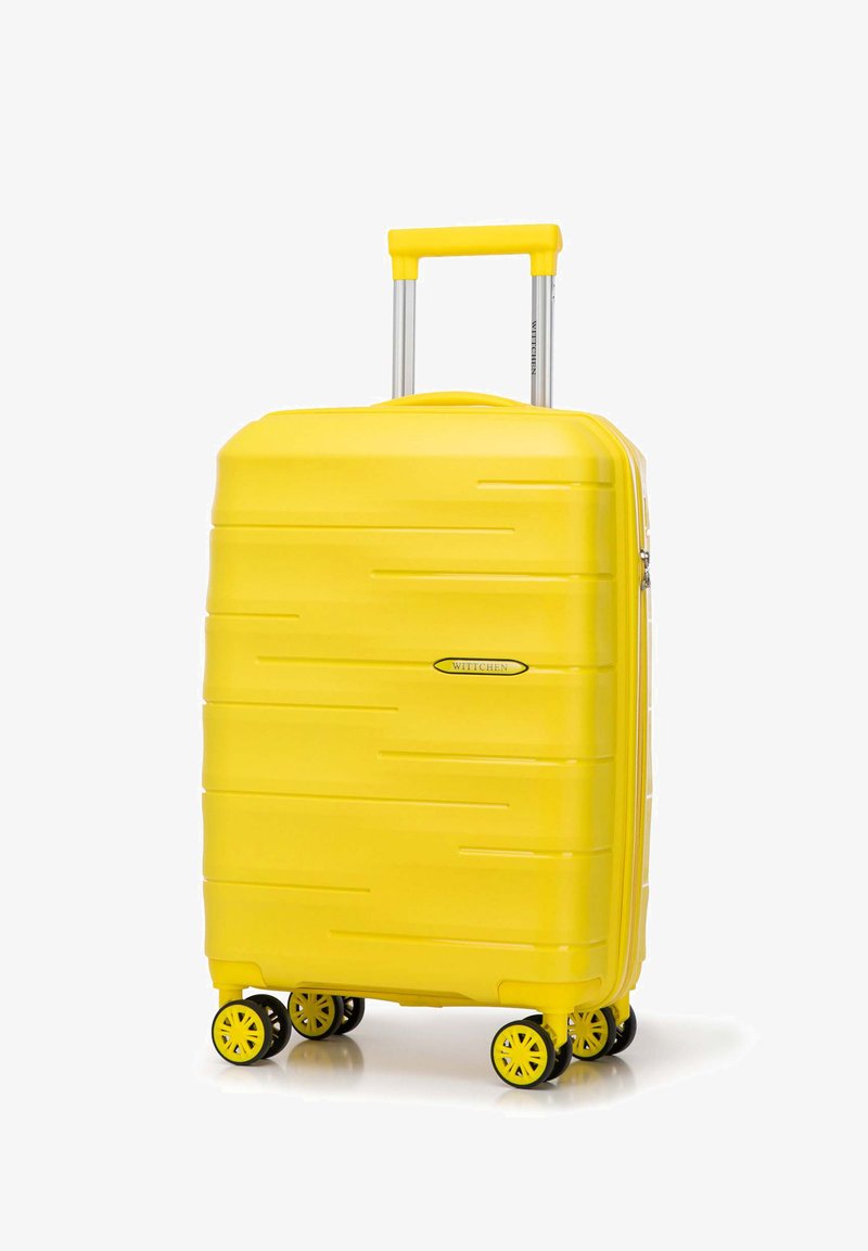 Gele harde koffer met een gladde textuur, horizontale groeven, een uittrekbare handgreep en vier gele wielen voor mobiliteit.