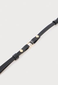 Μαύρο λουράκι από συνθετικό δέρμα με δύο στρογγυλές καρφίτσες σε χρυσό τόνο και μεταλλική αγκράφα, με λεία υφή και μινιμαλιστικό σχεδιασμό.