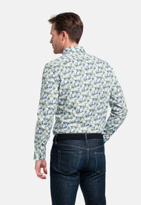 Bloemmotief shirt met een witte basis, voorzien van blauwe en groene botanische prints. Lange mouwen, button-down kraag en een slim fit ontwerp.