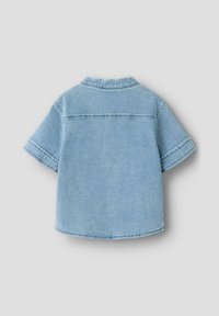 Lichtblauw denim overhemd met korte mouwen en kraag, met zichtbare stikdetails, gezien vanaf de achterkant op een effen lichtgrijze achtergrond.