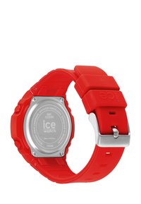 Red silicone wristwatch with a square case, stainless steel back, adjustable buckle closure, and textured strap. Water-resistant to 100 meters.