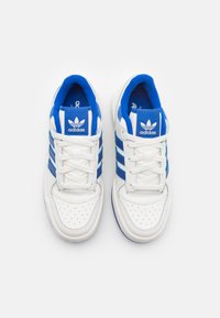 Adidași din piele albă cu accente albastre, având trei dungi, un vârf perforat și o limbă căptușită. Logo pe toc și pe limbă.