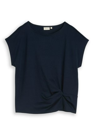 Blouse bleu marine à manches courtes avec encolure ronde et détail noué sur le côté inférieur droit, taille moyenne.