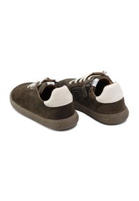 Zapatillas deportivas de ante marrón con detalles en cuero blanco, superficie texturizada, punta redonda, cierre con cordones y cremallera, suela de goma y diseño de perfil bajo.