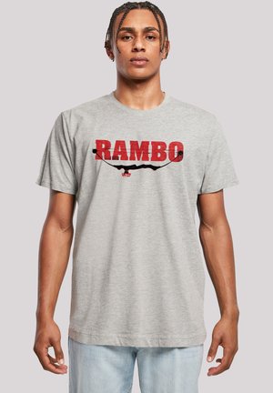 Gray cotton t-shirt featuring the word "RAMBO" in bold red letters and a black graphic design element. Short sleeves with a classic cut.