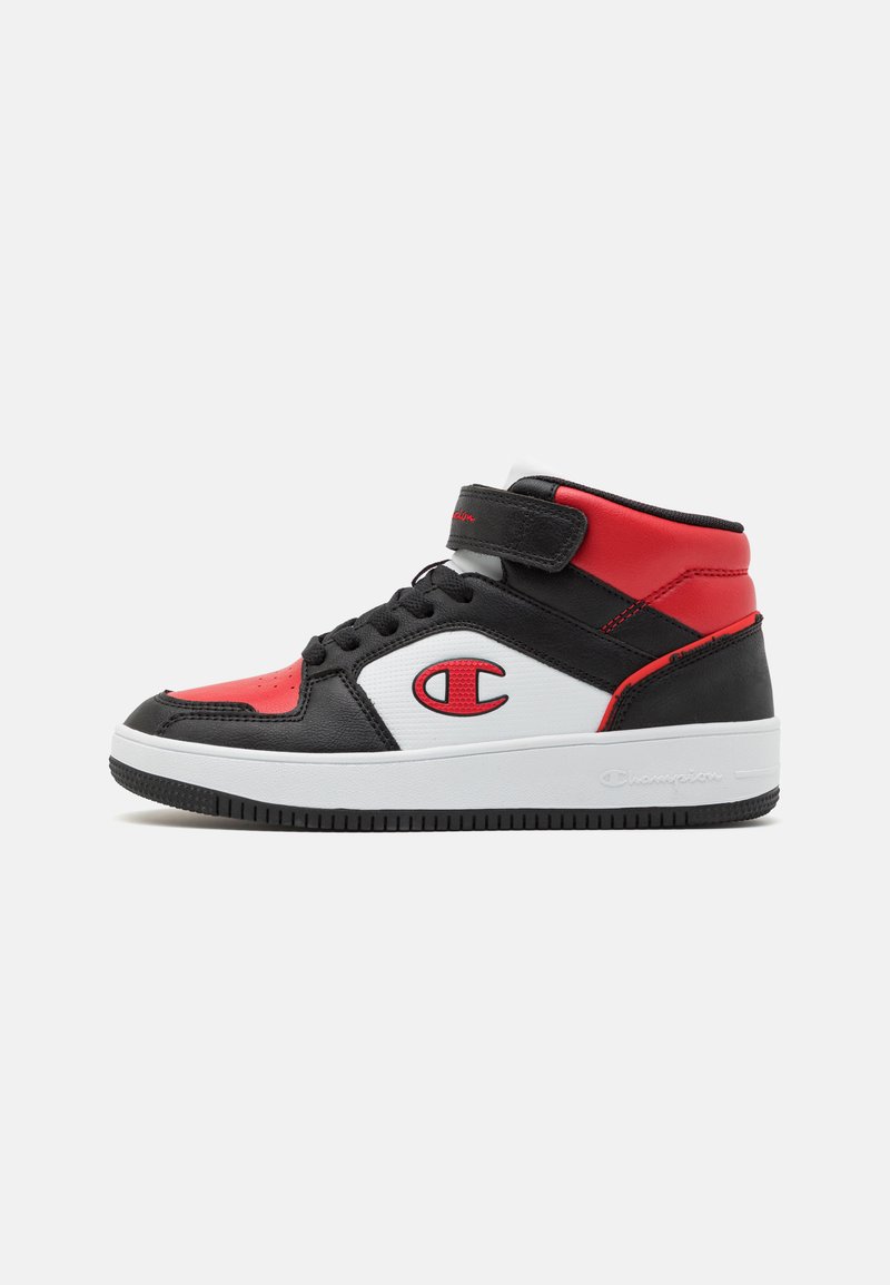 Høye sneakers med svart læroverside, røde og hvite detaljer, borrelåsrem og en teksturert gummisåle.
