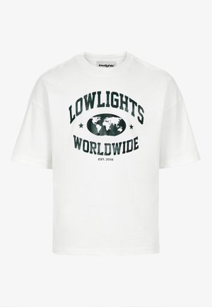 T-shirt en coton blanc avec un texte noir indiquant "LOWLIGHTS WORLDWIDE", un graphique de globe et des étoiles. Manches courtes, design col rond.