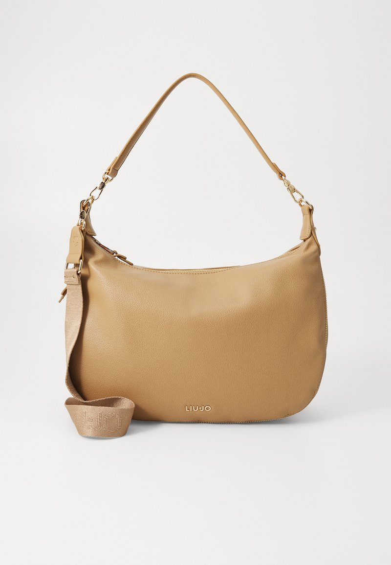 Sac à épaule en cuir tan avec une texture lisse, une bandoulière réglable et des accessoires en or. Présente un logo embossé à l'avant.