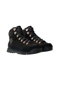 Bottes de randonnée noires avec tige en daim, semelle en caoutchouc et œillets dorés. Elles présentent des lacets texturés et un rembourrage à la cheville pour un soutien.