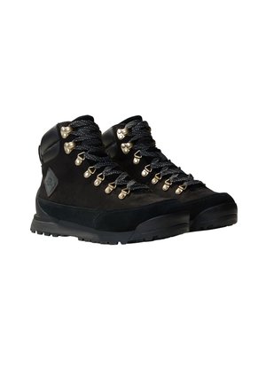 Botas de caminhada pretas com parte superior em camurça, sola de borracha e ilhós dourados. Apresentam atacadores texturizados e tornozeleira acolchoada para suporte.