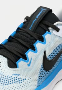 Les chaussures Nike Pegasus 41 présentent un dessus en mesh respirant de couleur bleu clair et noir, avec un emblématique swoosh noir de Nike et des lacets texturés.