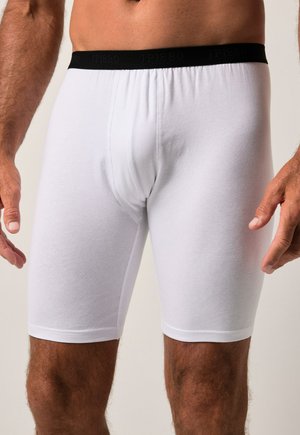 Boxeurs blancs en coton lisse avec une ceinture élastique noire portant le nom de la marque "JP1880" tissé en noir.
