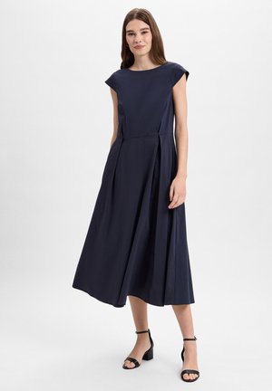 Robe bleu marine, longueur genou, avec des manches courtes, dotée d'un corsage ajusté et d'une jupe plissée. Tissu lisse et léger avec un design épuré.