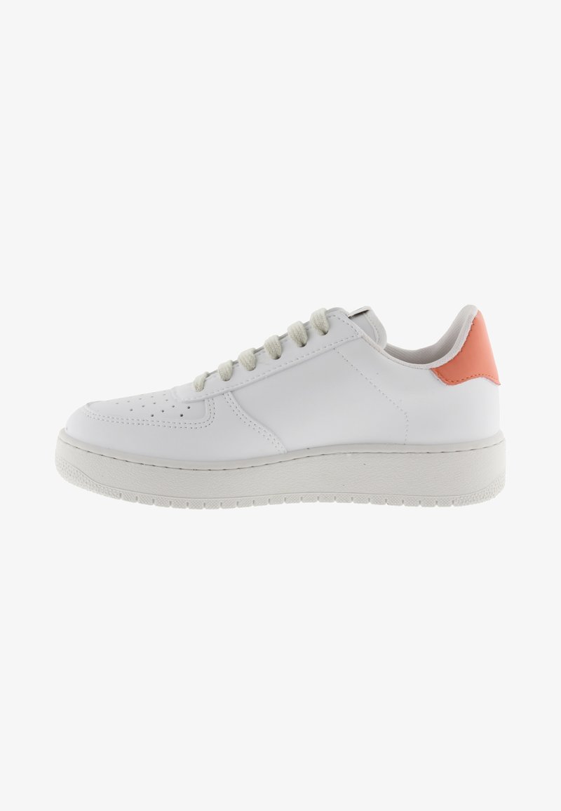 Zapatilla baja blanca con cordones beige y una tira en el talón de color coral naranja, que presenta una suela gruesa y texturizada y una área de puntera perforada.