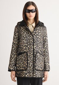 Beige a černá prošívaná bunda s leopardím potiskem, s kapucí, dvěma velkými předními kapsami a kontrastním černým lemem.