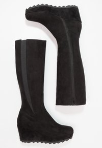 Mustat mokka-tyyliset platform-bootsit, joissa on sivuvetoketju. Niissä on tekstuuripinta, pyöristetty kärki ja elastinen paneeli tiiviiseen istuvuuteen.