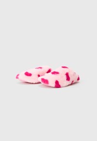 Pink fuzzy slippers with a soft texture, featuring dark pink heart-shaped patterns across the surface, rounded shape, and no visible hardware.