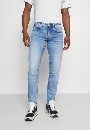 Lichtblauwe denim jeans met een slim fit, voorzien van vijf zakken, lichte wassing en een groene knoopdetail bij de tailleband.
