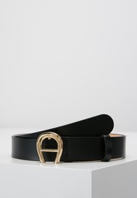 Schwarzer Ledergürtel mit glatter Oberfläche, ausgestattet mit einer goldfarbenen D-förmigen Schnalle. Der Gürtel hat ein minimalistisches Design mit einem polierten Erscheinungsbild.