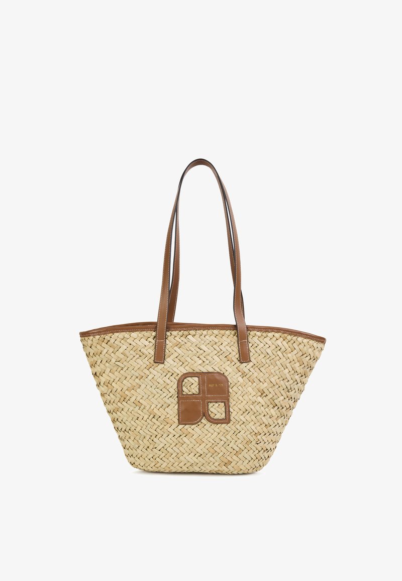 Sac cabas en paille tissée avec détails en cuir marron, double poignée, base rectangulaire et un patch texturé présentant un motif carré.