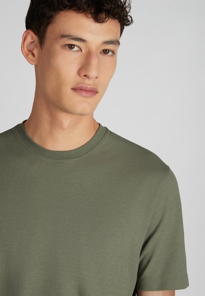 Camiseta de algodón verde oliva de cuello redondo con mangas cortas, que presenta una textura suave y dobladillos cosidos, ajustada alrededor del escote.
