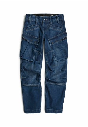 Ciemnoniebieskie spodnie cargo z denimu z wieloma kieszeniami i klapami na zatrzaski, prostymi nogawkami i szlufkami na pasek na białym tle.