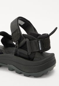 Must have mustarased sandaalid tekstuursete rihmadega, reguleeritavad velcro kinnitused ja paks, robustne tallaosa, millel on haardemustrid.