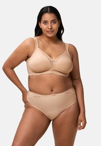 Nude spodní prádlo set obsahující podprsenku s krajkovým překrytím, nastavitelné ramínka a odpovídající vysoké kalhotky, hladký materiál a uvolněný střih.