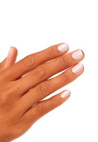 Vernis à ongles rose clair sur des doigts manucurés avec une texture lisse ; main affichée sur un fond blanc uni.