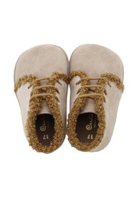 Zapatos de ante para niños pequeños en beige con ribete rizado marrón, con punta redondeada y dos cordones a juego. Textura suave y diseño minimalista.