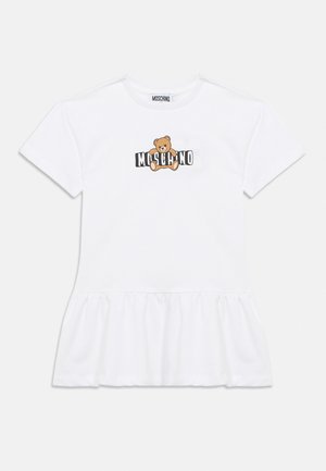 Bijela haljina kratkih rukava s nabranim rubom, s grafikom plišanog medvjedića i natpisom "MOSCHINO" na prsima.