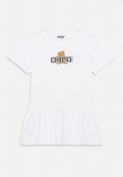 Robe blanche à manches courtes avec ourlet à volants, ornée d'un motif d'ourson et du texte "MOSCHINO" sur la poitrine.