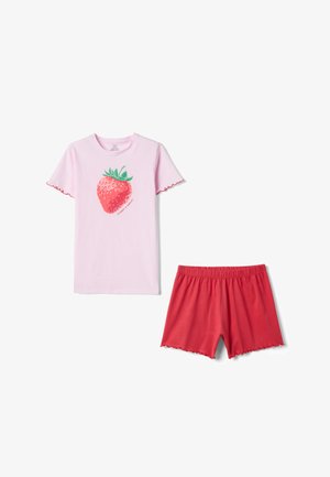 Haut rose clair à manches courtes avec un grand motif fraise et shorts rouges à bord festonné avec ceinture élastique.