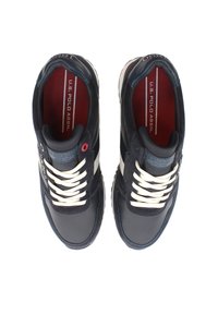 Granatowe sneakersy wykonane ze skóry i siateczki, z białymi sznurówkami, teksturowanymi akcentami i czerwonym wnętrzem. Logo marki widoczne na języku.