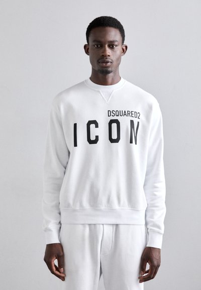 Sweat-shirt blanc avec un col rond et des poignets côtelés. L'avant affiche "DSQUARED2" et "ICON" en lettres noires en gras.