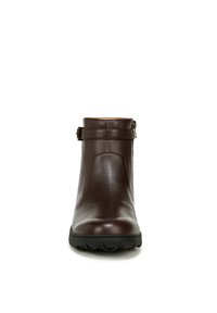 Bottines en cuir marron avec une texture lisse, bout rond, petit talon et un détail de sangle ajustable autour de la tige.