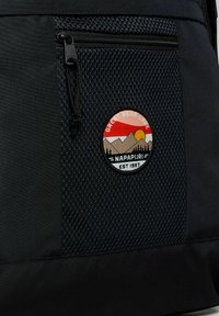 Zaino nero con pannello in rete testurizzata, tasca con zip e toppa circolare con montagne e "Great Bear Lake". Materiale in nylon resistente.