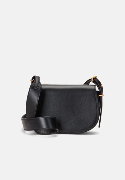 Melna ādas crossbody soma ar izliekta formu, kurai ir gluda tekstūra, zelta toņa detaļas un regulējama siksna.