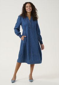Jeansklänning med långa puffärmar, knäppt krage, sidofickor, medellång, i en enhetlig blå färg med sömmar detaljer.