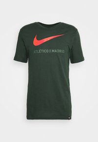 Tmavě zelené bavlněné tričko s velkým červeným logem Nike a textem "Atlético de Madrid" v zelené barvě. Krátké rukávy a kulatý výstřih.
